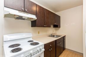 New London apartment for rent - A white stove in a kitchen with brown cabinets at Mohican Apartments, New London, Connecticut