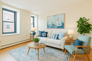 New London apartment for rent - A living room with a white couch, blue pillows, a wooden coffee table, and a painting on the wall.