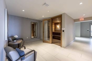 A modern living room with a grey sofa and a wooden door.