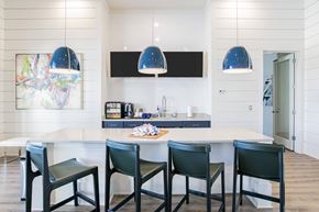 Daphne apartment for rent - A modern kitchen with a white table and black chairs.