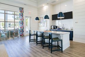 Daphne apartment for rent - A kitchen with a white counter and black chairs.