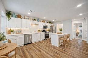 Virginia Beach apartment for rent - A kitchen with white cabinets and wooden floors.