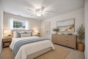 Virginia Beach apartment for rent - A bedroom with a bed, nightstands, and a ceiling fan.