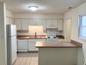 Virginia Beach townhouse for rent - A kitchen with white appliances and cabinets.