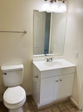 Chesapeake townhouse for rent - A white toilet sits next to a white sink in a bathroom.