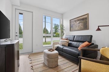 Surrey apartment for rent - A living room with a black leather couch and a flat screen TV.