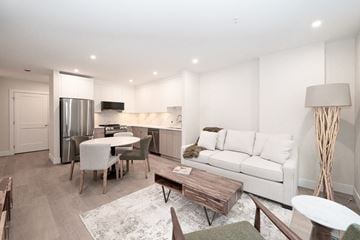Victoria apartment for rent - A modern living room with a white couch and a wooden coffee table.