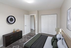 Prince George apartment for rent - A bedroom with a bed, dresser, and a clock on the wall.