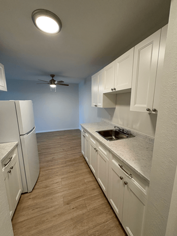 Courtenay apartment for rent - A kitchen with white cabinets and a ceiling fan.