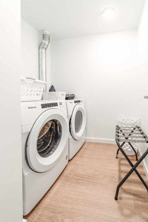Prince George apartment for rent - A laundry room with a washer and dryer and a folding chair.