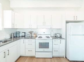 Prince George apartment for rent - A white kitchen with a refrigerator on the right.