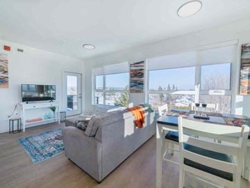 Prince George apartment for rent - A living room with a grey couch and a white chair.