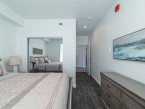 Prince George apartment for rent - A bedroom with a large bed and a painting on the wall.