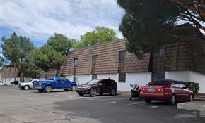 Carlsbad apartment for rent - A parking lot with cars and a building in the background.