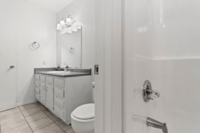 Carlsbad apartment for rent - A white bathroom with a toilet, sink, and mirror.