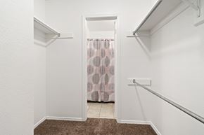 Carlsbad apartment for rent - A white hallway with a brown carpet and a doorway leading to a bathroom.