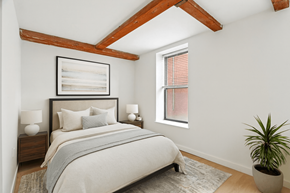 Dorchester apartment for rent - A bedroom with a large bed and a potted plant.