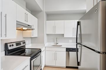 Dorchester apartment for rent - A modern kitchen with white cabinets and stainless steel appliances.