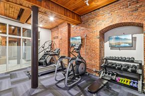 Dorchester apartment for rent - A gym with a brick wall and a row of treadmills.