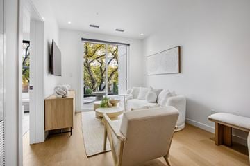 Edmonton apartment for rent - A living room with a white couch and a wooden chair.