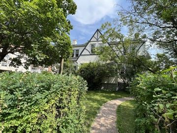 Edmonton apartment for rent - A pathway leads through a lush green garden to a house.