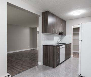 Edmonton apartment for rent - A kitchen with brown cabinets and a white dishwasher.