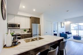 Edmonton apartment for rent - A modern kitchen with a large island and a dining area.