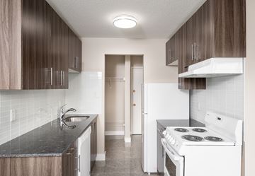 Edmonton apartment for rent - A kitchen with a white stove and a black countertop.