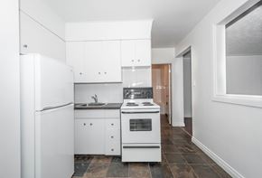 Edmonton apartment for rent - A white kitchen with a refrigerator, sink, and stove.