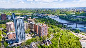 Edmonton apartment for rent - A cityscape with a river and a bridge in the background.