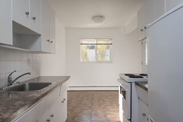 Edmonton apartment for rent - A kitchen with white cabinets and a window.