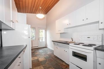 Edmonton apartment for rent - A modern kitchen with white cabinets and a wooden ceiling.