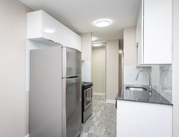 Edmonton apartment for rent - A kitchen with a refrigerator, oven, and sink.