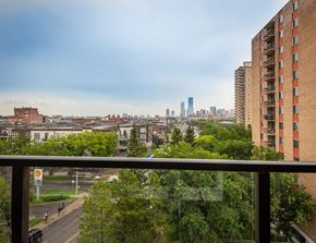 Edmonton apartment for rent - A view of a city from a balcony with a car on the road.