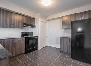 Edmonton townhouse for rent - A kitchen with a black refrigerator, stove, and oven.