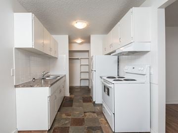 Edmonton apartment for rent - A kitchen with white appliances and cabinets.