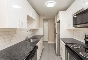 Edmonton apartment for rent - A kitchen with black countertops and white cabinets.