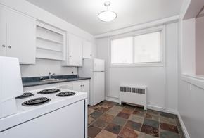 Edmonton apartment for rent - A kitchen with white appliances and cabinets.