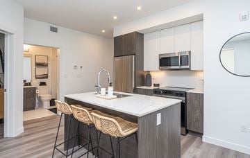 Edmonton apartment for rent - A modern kitchen with a white countertop and wooden cabinets.