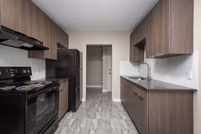 Edmonton apartment for rent - A kitchen with black appliances and wooden cabinets.