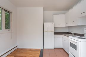 Edmonton apartment for rent - A kitchen with white appliances and cabinets.