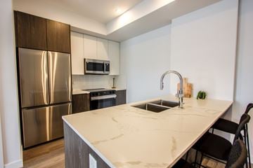 Edmonton apartment for rent - A kitchen with a stainless steel refrigerator and a white countertop.