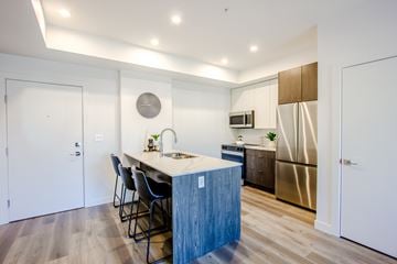 Edmonton apartment for rent - A kitchen with a white counter top and a stainless steel refrigerator.