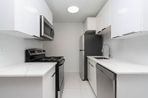 Edmonton apartment for rent - A white kitchen with black appliances and a white counter top.