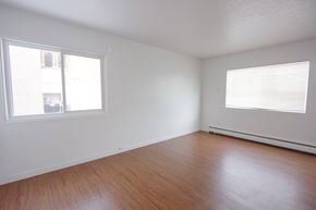 Edmonton apartment for rent - Empty room with wooden floor and two windows.