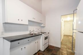Edmonton apartment for rent - A kitchen with white cabinets and a black counter top.