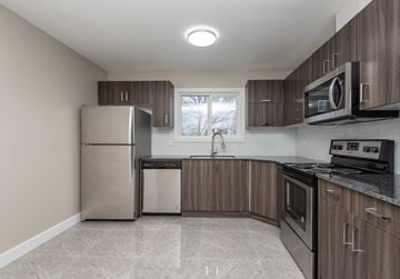Edmonton apartment for rent - A kitchen with a refrigerator, microwave, and oven.