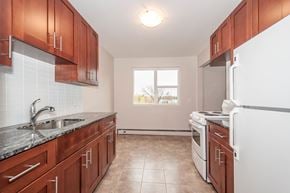 Edmonton apartment for rent - A kitchen with brown cabinets and a white refrigerator.