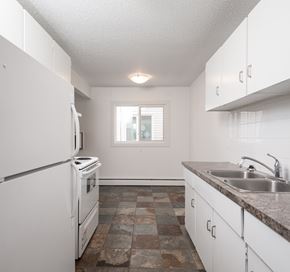Edmonton apartment for rent - A kitchen with white appliances and cabinets.