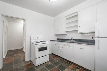 Edmonton apartment for rent - A kitchen with white appliances and cabinets.